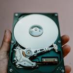 Close-up view of an open hard drive held in a hand, illustrating data storage technology.